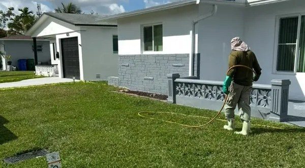 A Non-Stop technician treating a front lawn