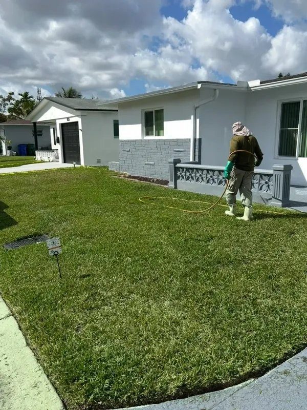 A Non-Stop technician treating a front lawn